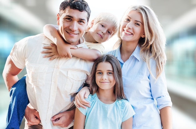 Jeune famille à la maison souriant à la caméra