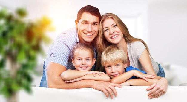 Jeune famille à la maison souriant à la caméra