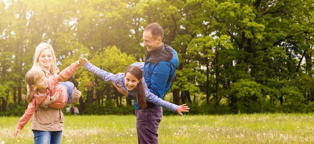 la jeune famille marche dans un champ vert