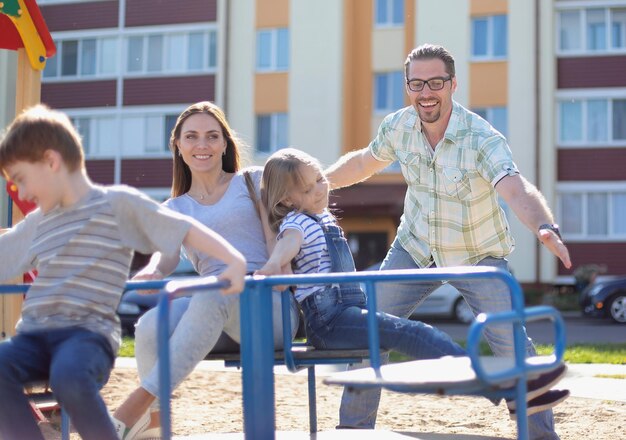 Jeune famille moderne avec des enfants jouant dans le concept de vacances Playgroundfamily