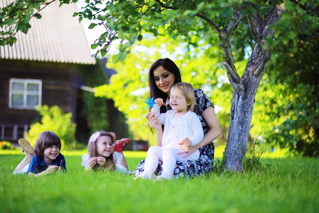 Jeune famille nombreuse lors d'une promenade matinale d'été. Belle mère avec enfants joue dans le parc.