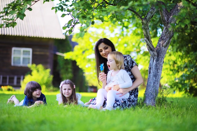 Jeune famille nombreuse lors d'une promenade matinale d'été Belle mère avec enfants joue dans le parc