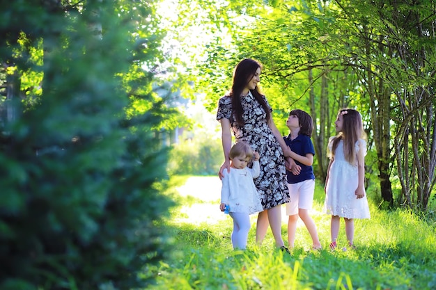 Jeune Famille Nombreuse Lors D'une Promenade Matinale D'été Belle Mère Avec Enfants Joue Dans Le Parc