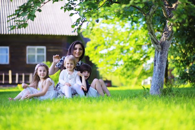 Jeune famille nombreuse lors d'une promenade matinale d'été Belle mère avec enfants joue dans le parc