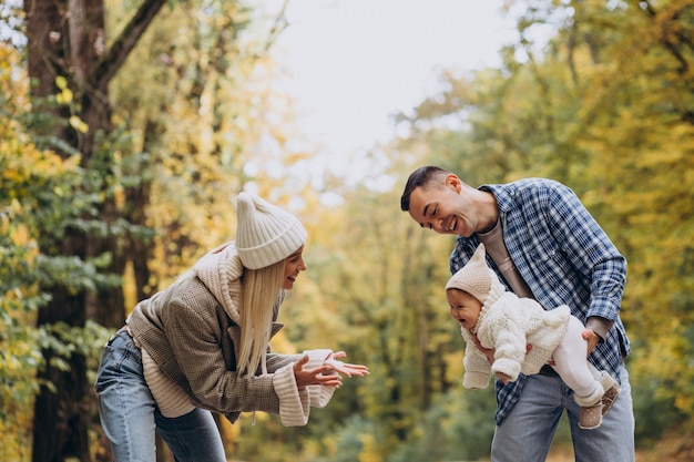 Jeune famille avec petite fille dans le parc d'automne