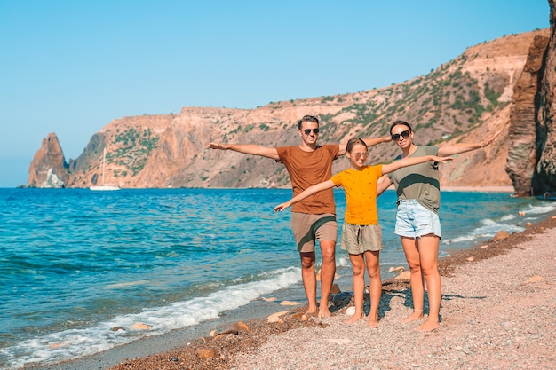 Jeune famille sur la plage blanche pendant les vacances d'été