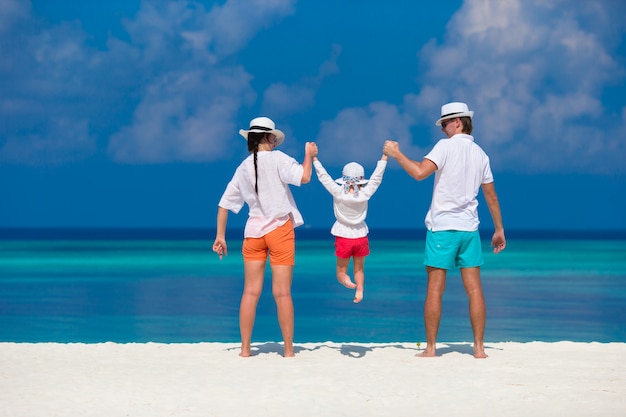 Jeune famille sur la plage blanche pendant les vacances d'été