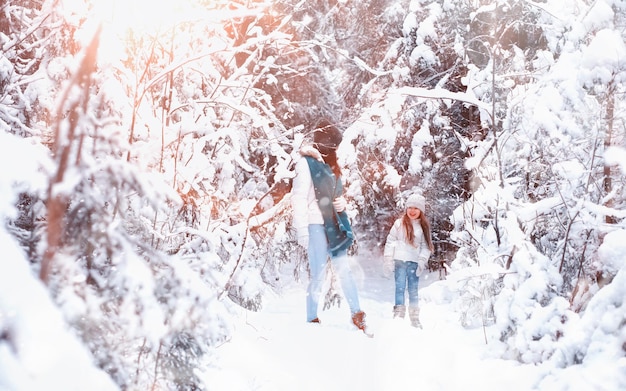 Jeune famille pour une promenade. Maman et sa fille marchent dans un parc d'hiver.