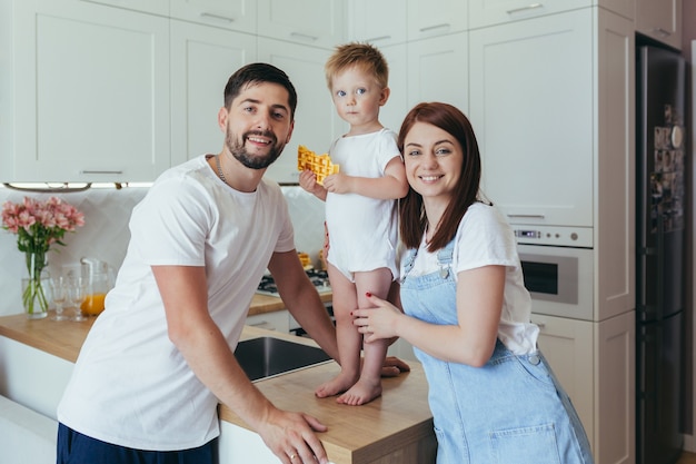 Jeune famille préparant le petit déjeuner ensemble, mari, femme et enfants