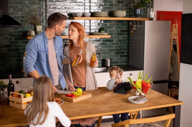 Une jeune famille prépare des légumes dans la cuisine.