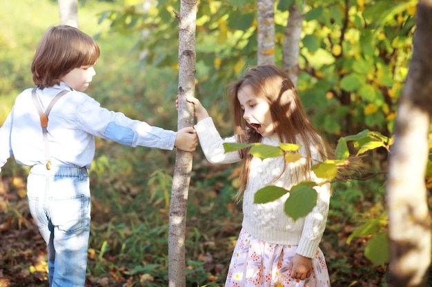 Jeune famille en promenade dans le parc en automne par une journée ensoleillée. Le bonheur d'être ensemble.