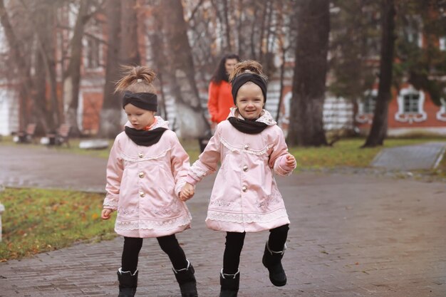 Jeune famille en promenade dans le parc en automne par une journée ensoleillée. Le bonheur d'être ensemble.