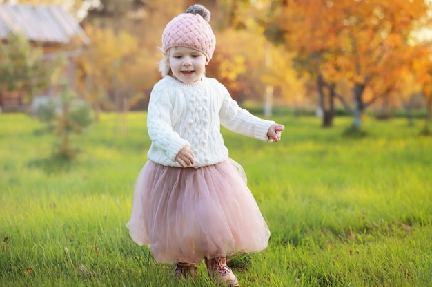 Jeune famille en promenade dans le parc en automne par une journée ensoleillée. Le bonheur d'être ensemble.