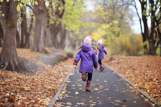 Jeune famille en promenade dans le parc d'automne par une journée ensoleillée Bonheur d'être ensemble