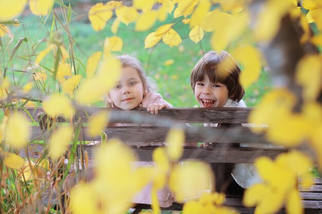 Jeune famille en promenade dans le parc d'automne par une journée ensoleillée Bonheur d'être ensemble