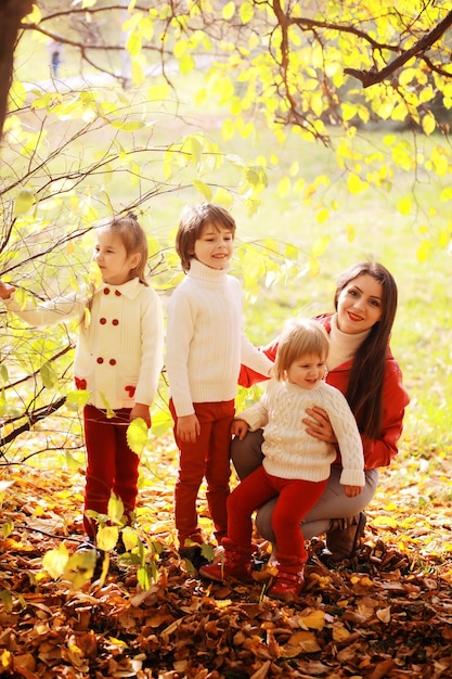 Jeune famille en promenade dans le parc d'automne par une journée ensoleillée Bonheur d'être ensemble