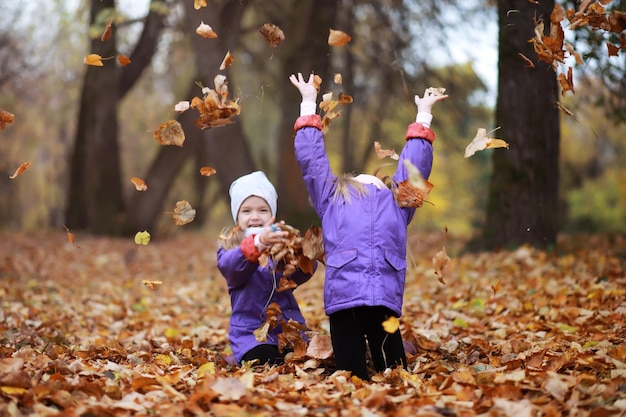 Jeune famille en promenade dans le parc d'automne par une journée ensoleillée Bonheur d'être ensemble