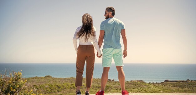 Jeune famille à la recherche de vacances de voyage loin heureux homme et femme tenant la main