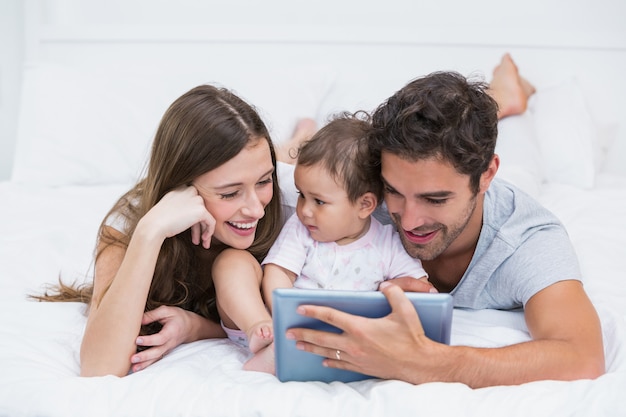 Jeune famille, regarder, tablette numérique, sur, lit