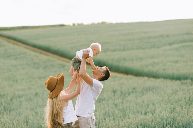 Une jeune famille s'amuse avec son petit bébé sur le terrain