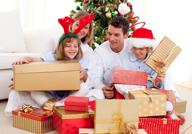 Jeune famille s&#39;amuser avec des cadeaux de Noël