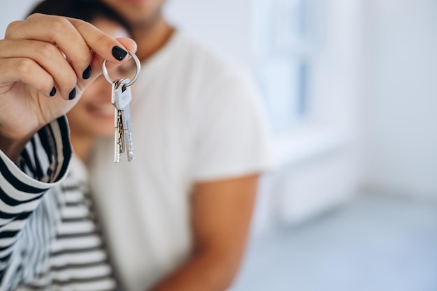 Photo jeune famille tenant les clés de leur nouvelle maison