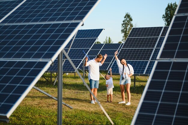 Photo une jeune famille de trois personnes est accroupi près d'un panneau solaire photovoltaïque petit garçon et ses parents concept de famille moderne le concept d'énergie verte