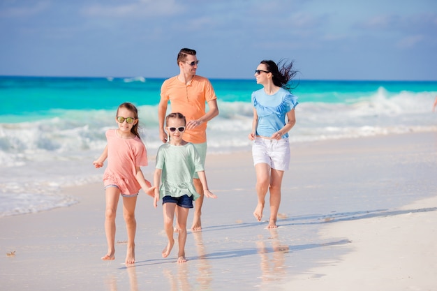 Jeune famille en vacances s'amuser sur la plage