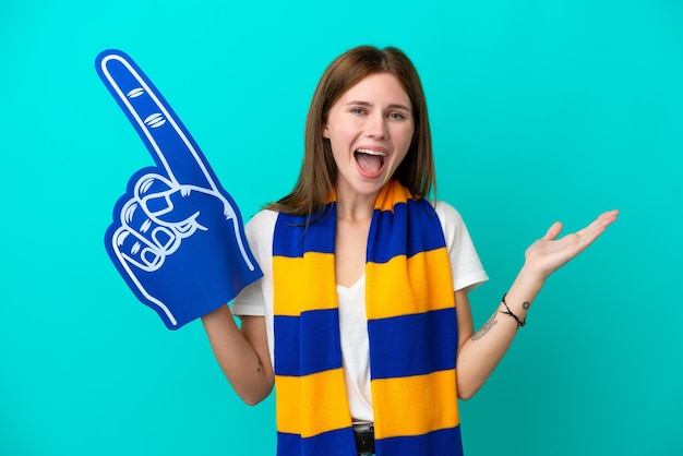 Jeune fan de sport femme isolée sur fond bleu avec une expression faciale choquée