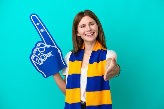 Jeune fan de sport femme isolée sur fond bleu se serrant la main pour conclure une bonne affaire