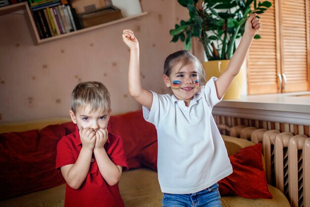 Jeune fan de sport regardant des matchs de sport et applaudissant son équipe à la télévision à la maison