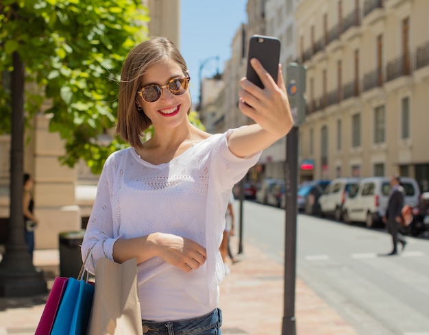 jeune femme avec des achats de téléphone portable