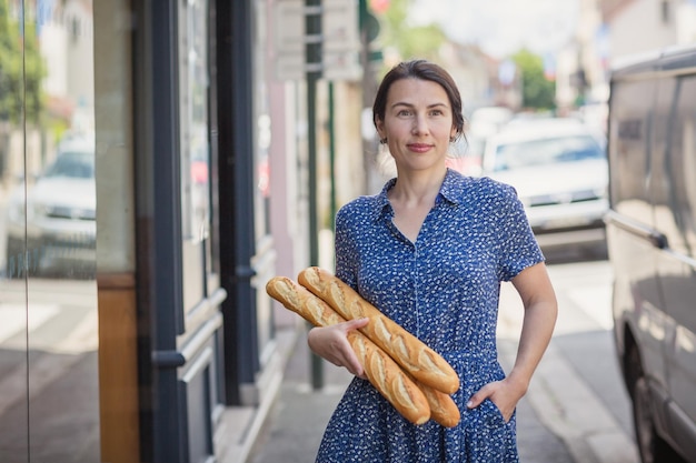 Jeune femme achetant une baguette française