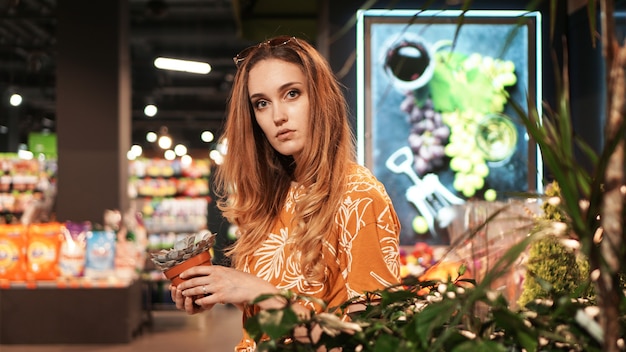 Jeune Femme Achetant Des Fleurs Dans Un Pot Dans Un Centre De Jardinage