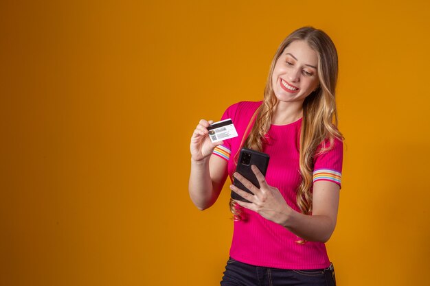 Jeune femme achetant en ligne avec une carte de crédit par téléphone