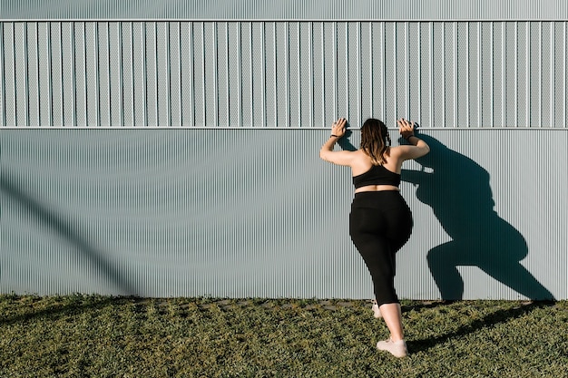 Jeune femme active qui s'étend à l'extérieur