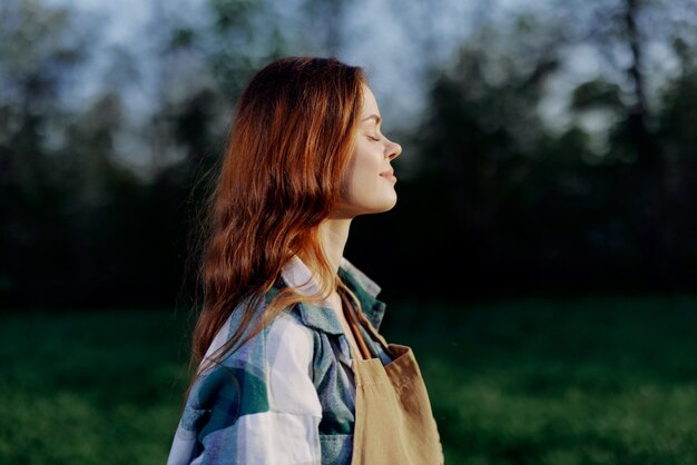 Jeune femme active se détendre dans la nature en été et regarder le coucher du soleil au loin