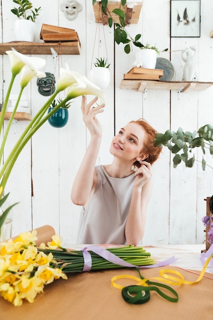 Jeune femme admire les belles fleurs en atelier