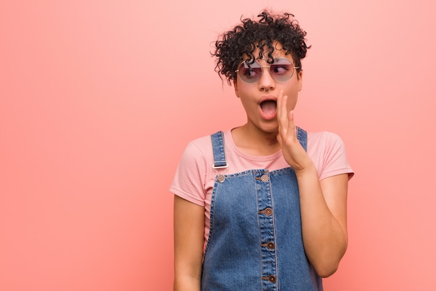 Jeune femme adolescente afro-américaine mixte dit une nouvelle secrète sur le freinage à chaud et regarde de côté