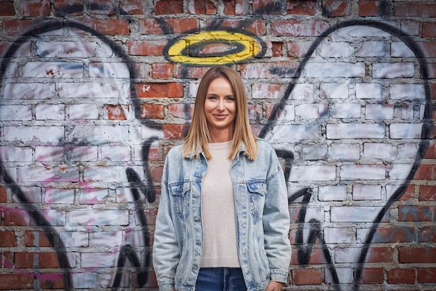 Jeune femme adulte avec une aile d'ange sur le mur