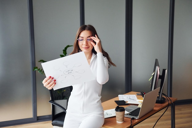 La Jeune Femme Adulte Dans Des Vêtements Formels Est à L'intérieur Dans Le Bureau