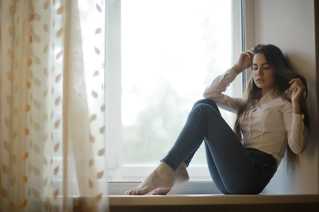 une jeune femme adulte à la fenêtre