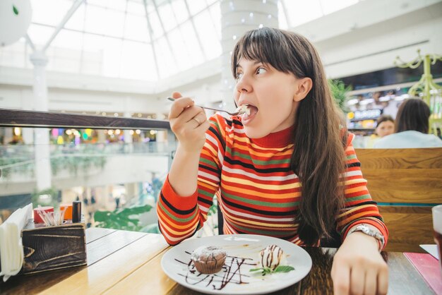 Jeune femme adulte mangeant du fondant au chocolat au café