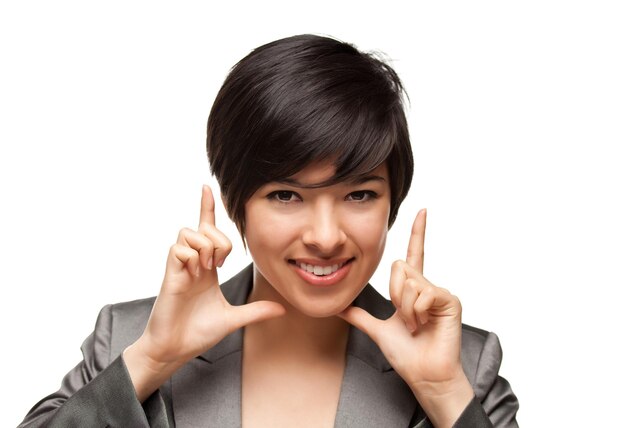 Une jeune femme adulte multiethnique souriante encadrant son visage avec ses mains.