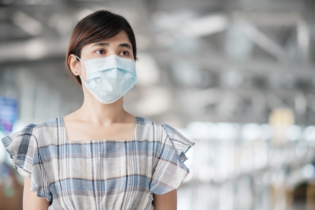 Jeune femme adulte portant un masque facial dans le terminal de l'aéroport