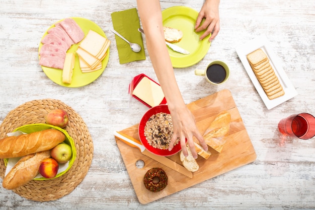 Une jeune femme adulte prépare un petit-déjeuner de style européen.