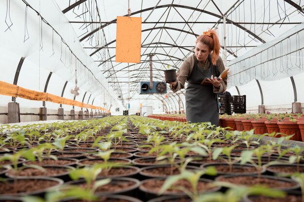 Jeune femme adulte travaillant dans une serre industrielle