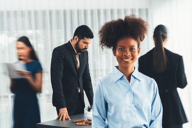 Une jeune femme d'affaires africaine pose en toute confiance dans la salle de réunion animée Concord