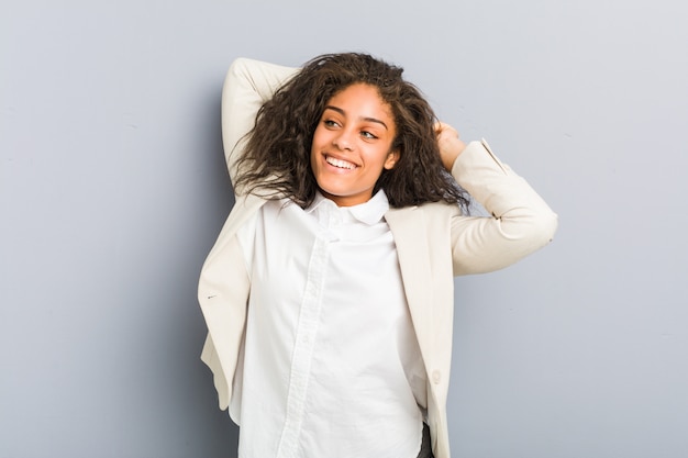 Jeune femme d'affaires afro-américaine, étirement des bras, position détendue.