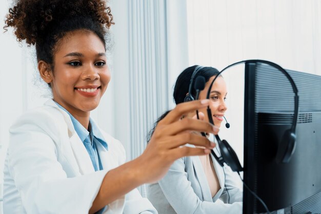 Jeune femme d'affaires afro-américaine portant un casque travaillant au bureau pour soutenir un client ou un collègue crucial à distance.